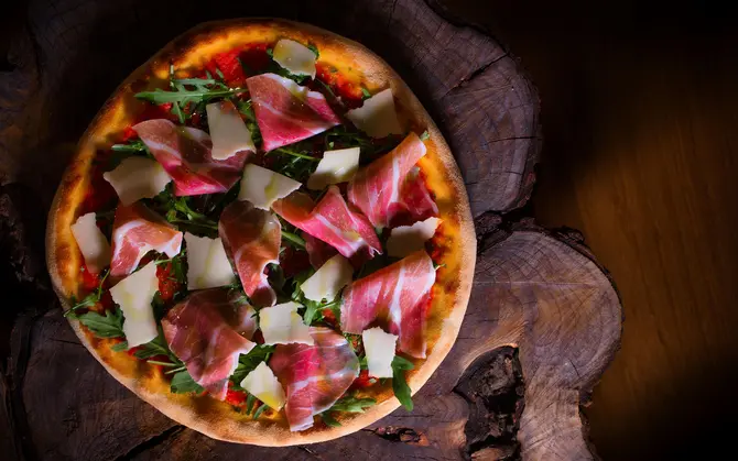 Pizza "Chef" mit Parmaschinken, Parmesan , Rucola-Salat und Trüffelöl 