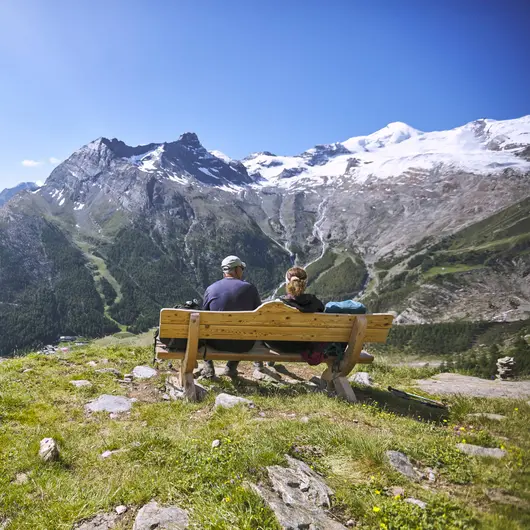 Deux personnes sur un banc dans les montagnes de Saas-Fee
