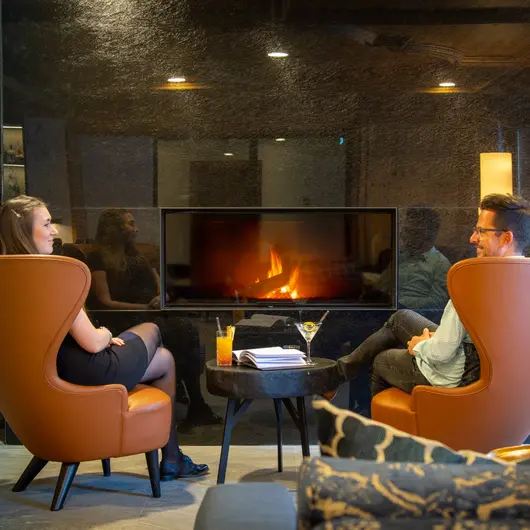 Two people in front of the fireplace
